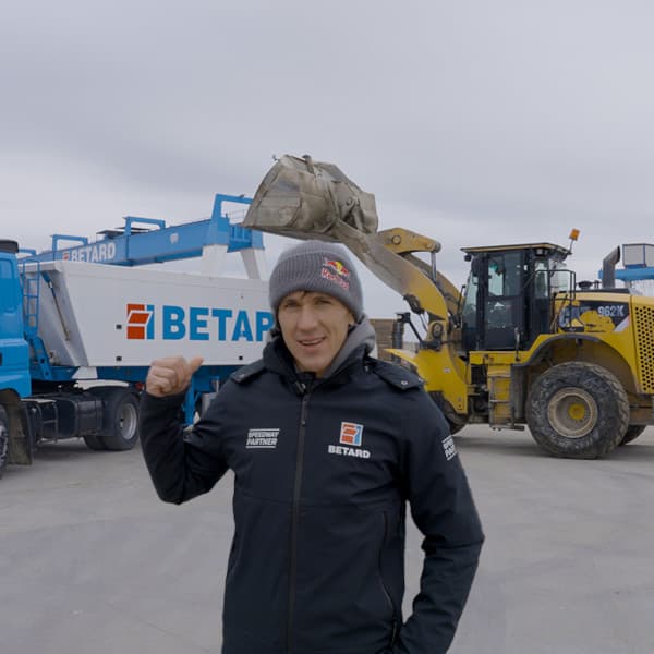 Maciej Janowski stoi przy aucie dostawczym i ładowarce na placu zakładowym Betard