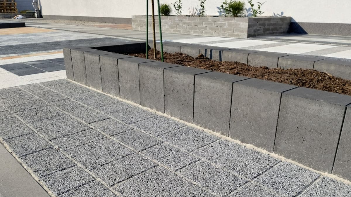 Nawierzchnie z kostki brukowej i betonowe kwietniki w ogródku wystawowym Betard