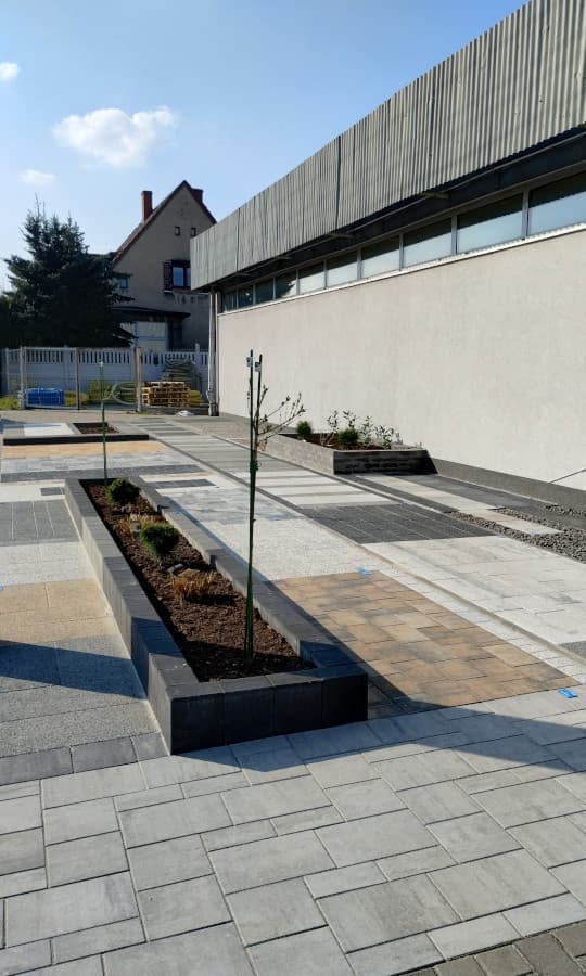 Nawierzchnie z kostki brukowej i betonowe kwietniki w ogródku wystawowym Betard