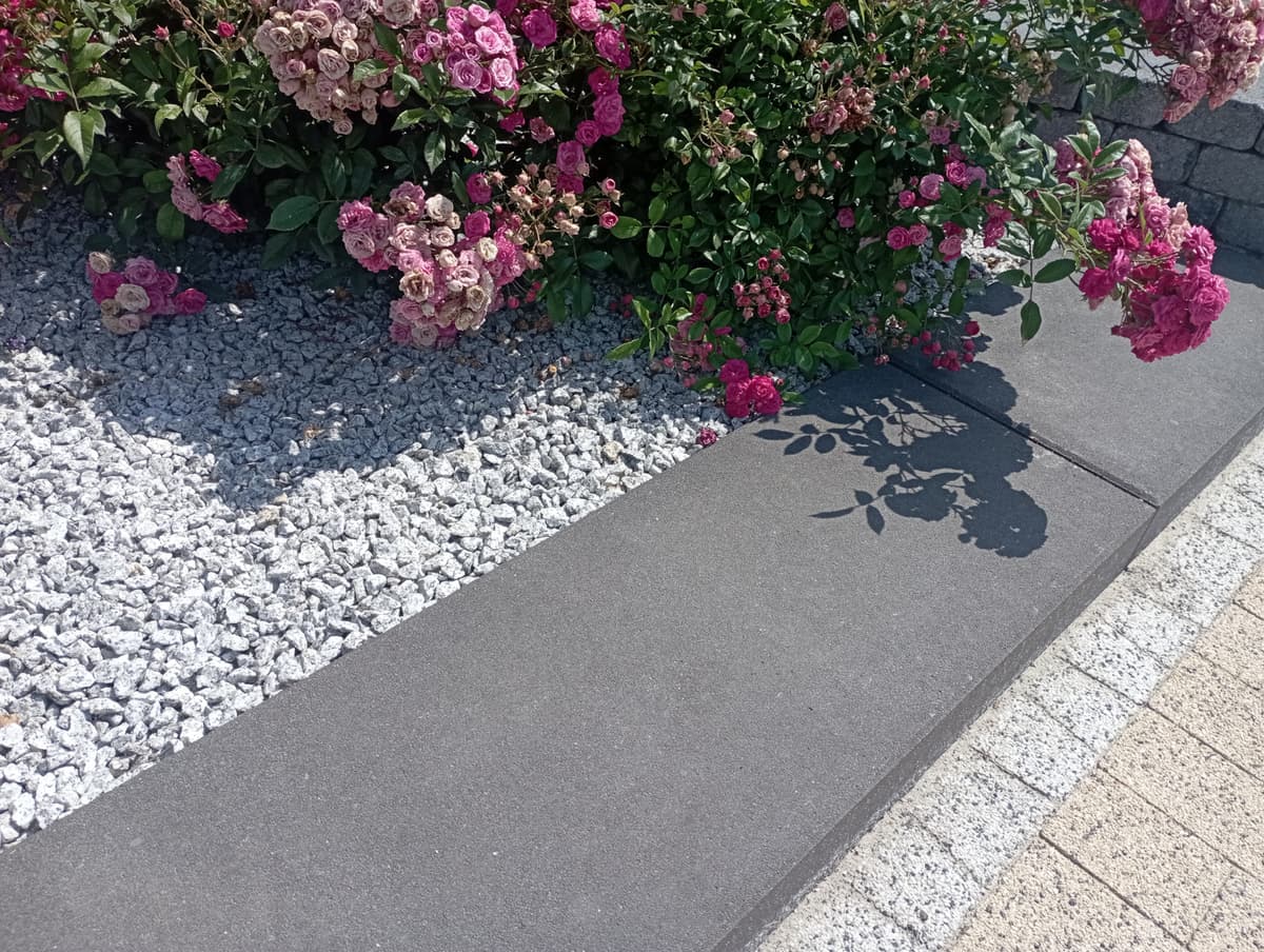 Stopień schodowy Scalino oddziela ścieżkę od kwietnika